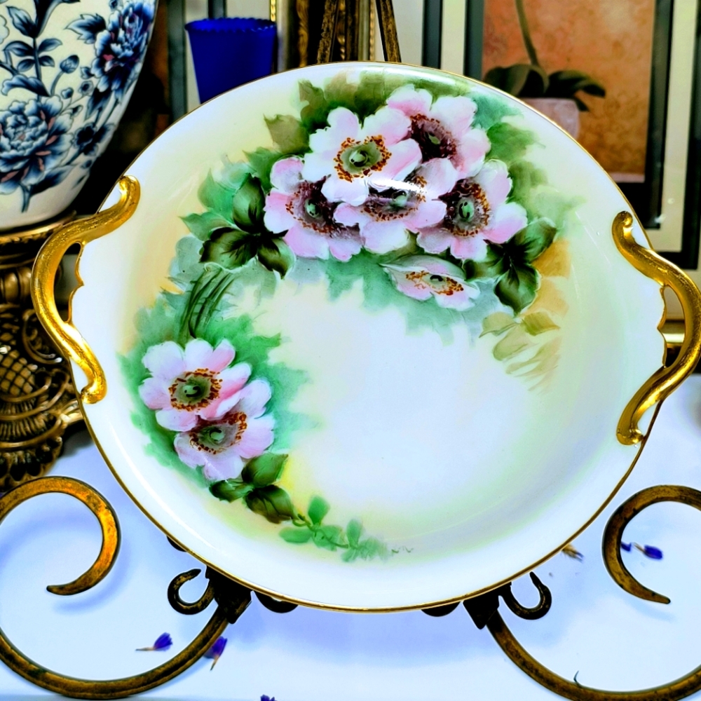 Stunning antique bowl with gold handles and hand painted.  I'm not sure who the